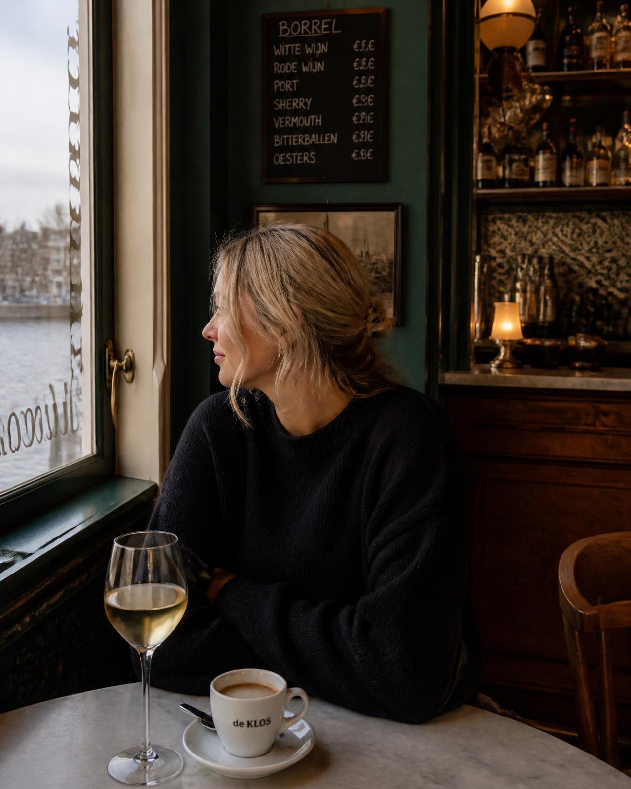 Sfeervol café-interieur met uitzicht op het water (sfeerbeeld — vervangbaar)